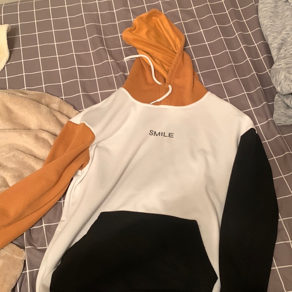 white hoodie with black pockets and brown and black sleeves